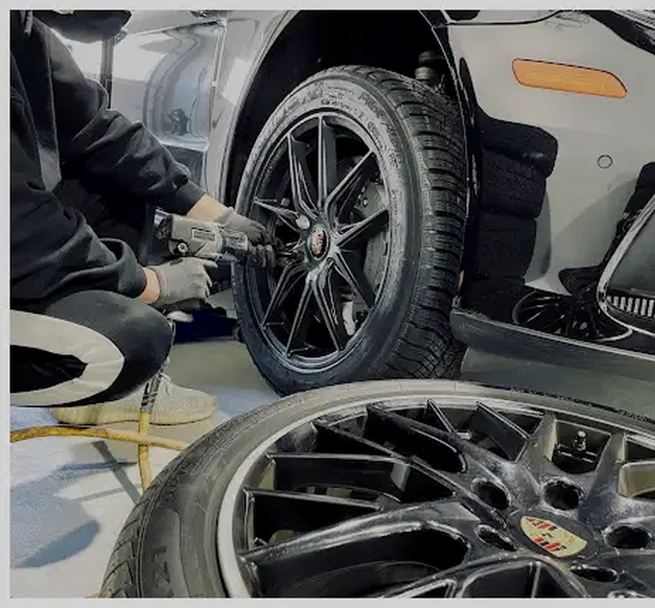 Tire technician changing a vehicle's wheel with an impact wrench
